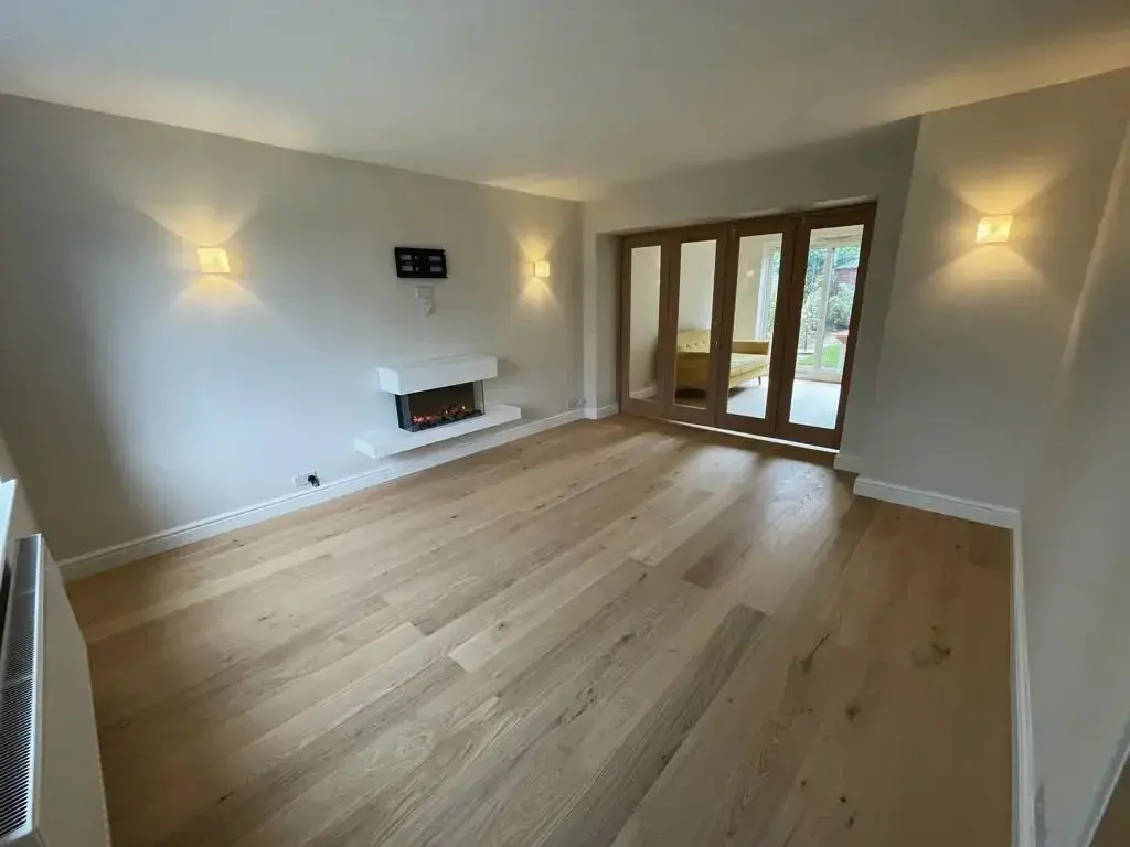 New living room with an oak floor, a wall-hung fireplace and glazed oak doors